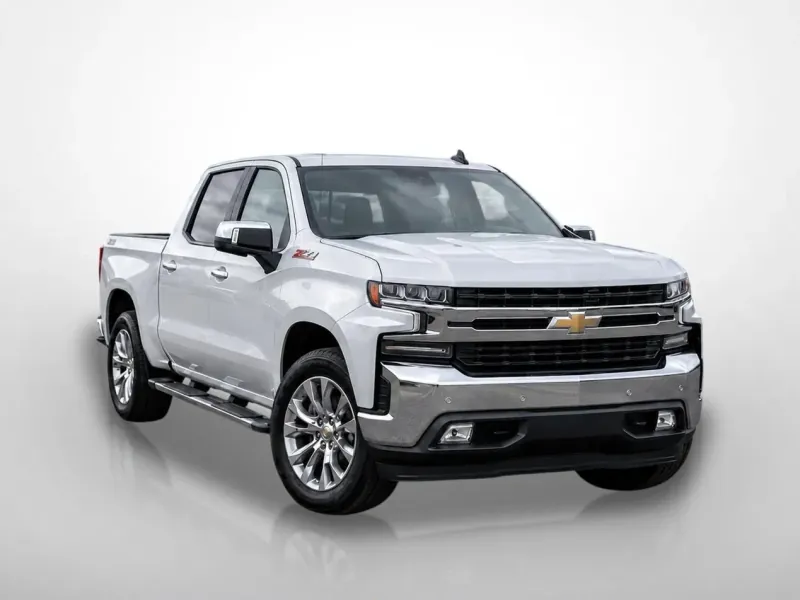 After: the same Silverado, unchanged, on a clean glassy showroom backdrop with a soft reflection