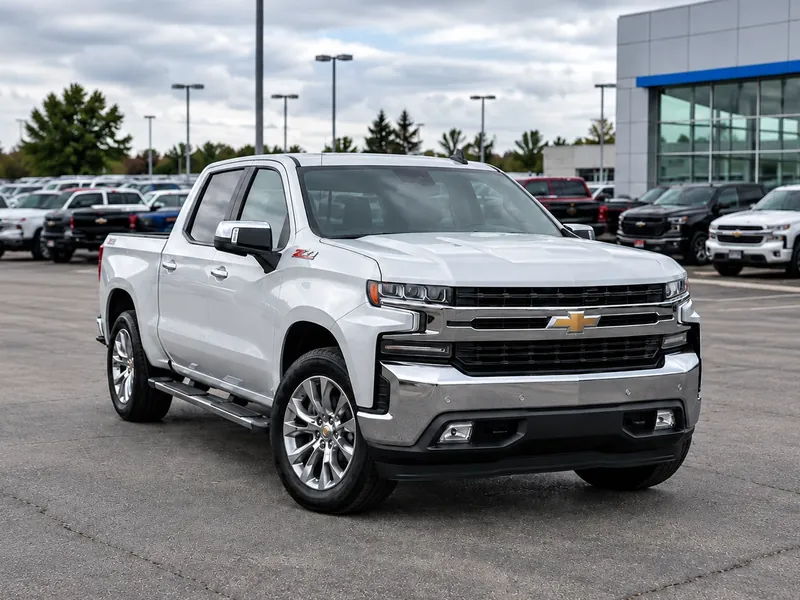 Before: a white Chevrolet Silverado photographed on a dealer lot, with parked trucks and the dealership building behind it
